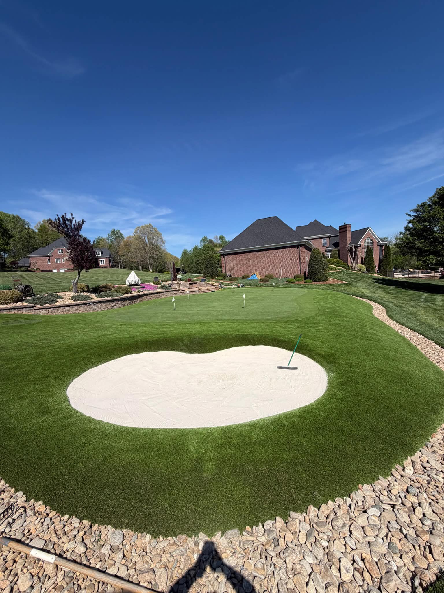 Low-maintenance golf green installation for a Fort Mill area home, featuring synthetic turf and a smooth putting surface.